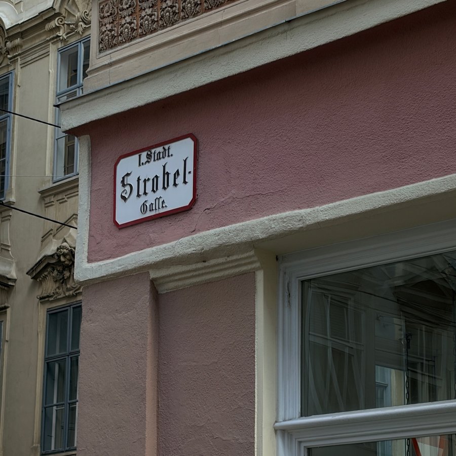 Historisches Straßenschild Strobelgasse an rosa Fassade